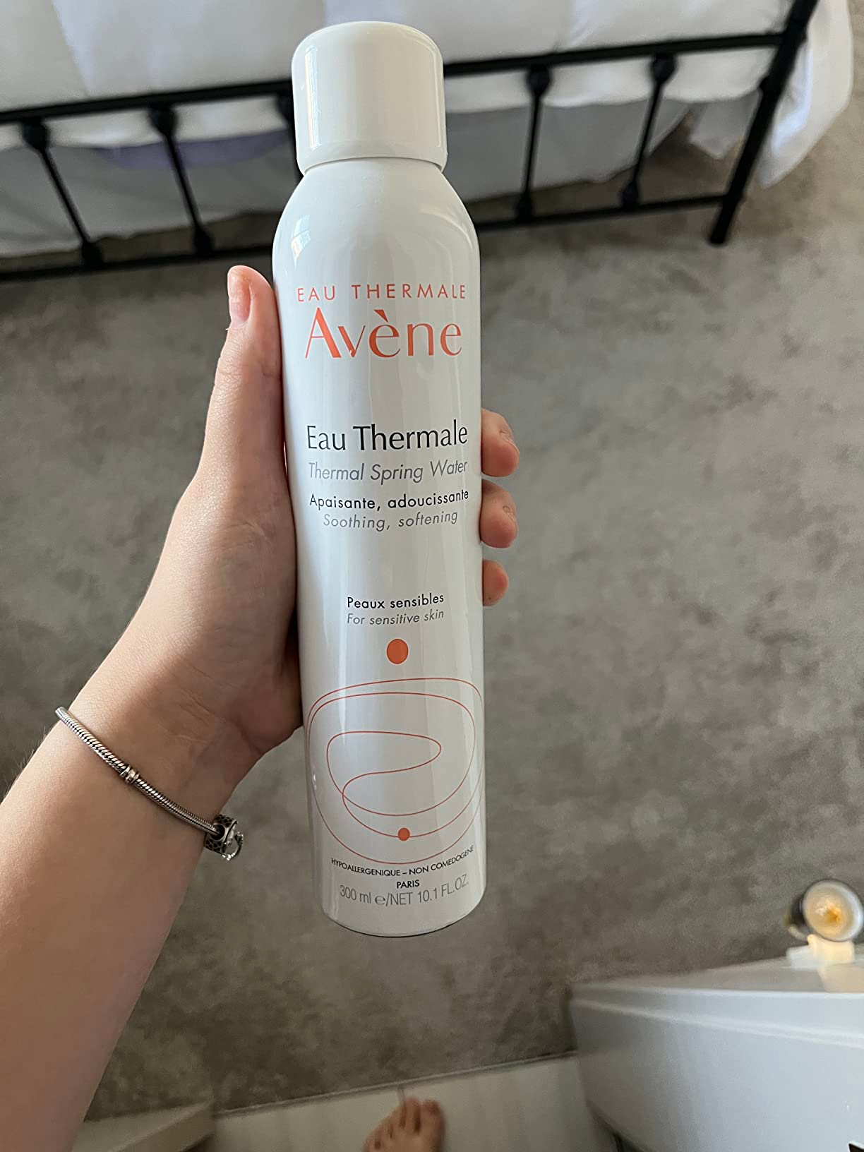 Person holding a 300ml tin  of Avène Eau Thermale Thermal Spring Water, labeled for soothing and softening delicate  skin