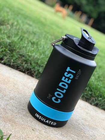 reviewer's water bottle in black and blue sitting outside