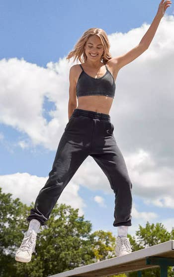 a model poses in the black pants with a matching sports bra