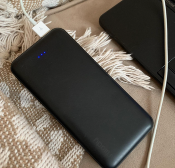 reviewer image of power bank with charging cable attached