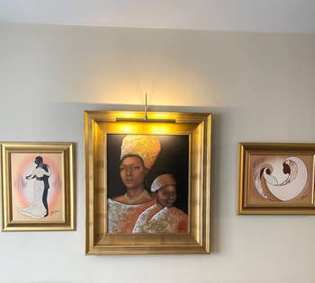 Three paintings with the light above the center painting
