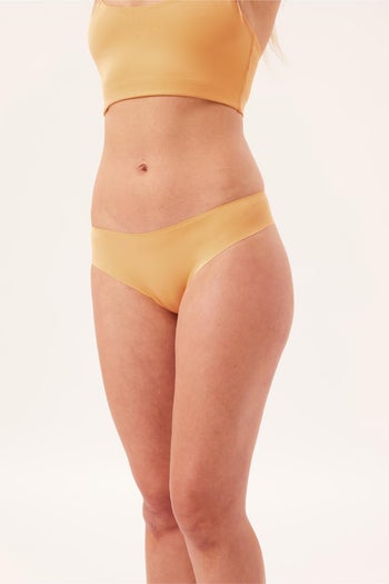 front of a model wearing a sporty seamless yellow thong