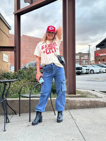 person successful casual outfit with a Kansas City t-shirt, cargo jeans, and ankle boots