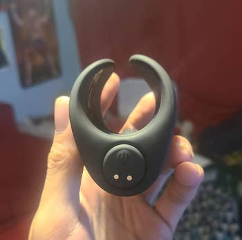 Same manus holding the aforesaid product, displaying the removable slug vibrator and charging buttons