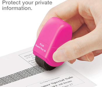 hand using the pink roller to cover up personal information on an envelope