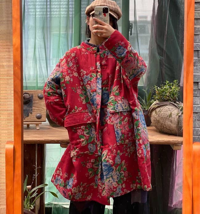 model wearing the long, oversized floral jacket with large pockets in the front