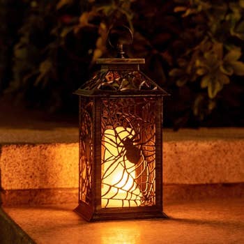retro candle lantern with hook to hold it and spider with web pattern 