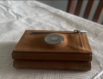 small metal disc clipped to a wallet 