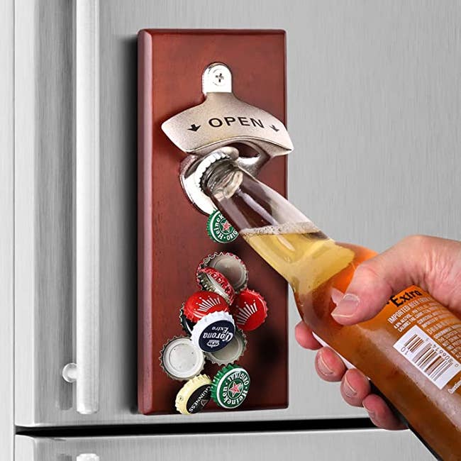 photo of the bottle opener on fridge and person using it to open a beer