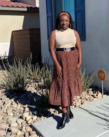 Reviewer is wearing a cream sleeveless top and a clay colored skirt with tiny white polka dots throughout