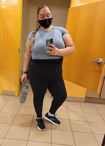 reviewer gym selfie wearing mask and blue short sleeve crop top