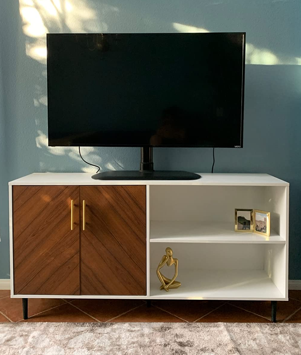 reviewer photo of the white and brown cabinet holding a tv and some decorative items