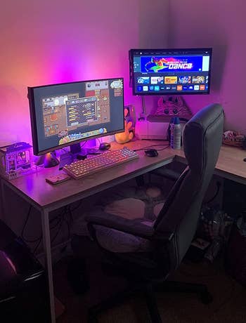 LED lights adding pink and orange backlighting to a desk setup