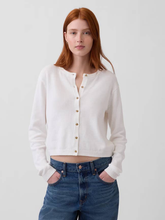 Person wearing a button-up cardigan and jeans, hands successful  pockets, suitable for casual buying  outfits
