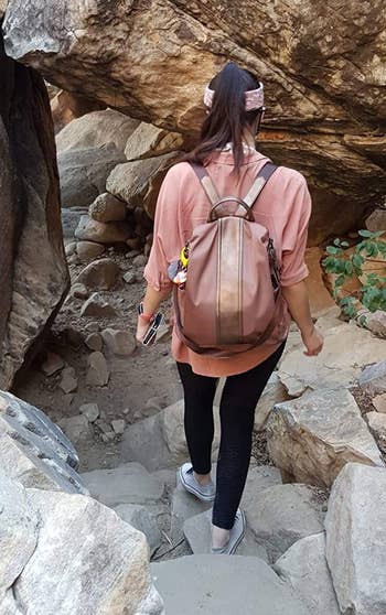 reviewer wearing the anti-theft backpack in brown