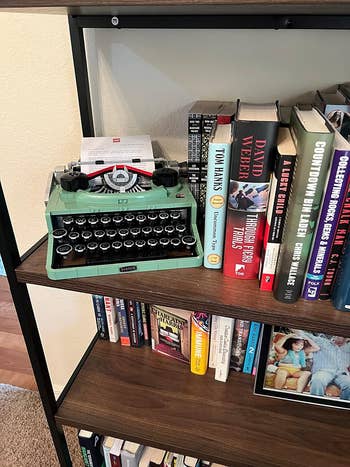 lego typewriter on a shelf among various books