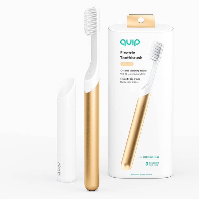 A white toothbrush with a gold bottom, plus a white holder to keep it upright 