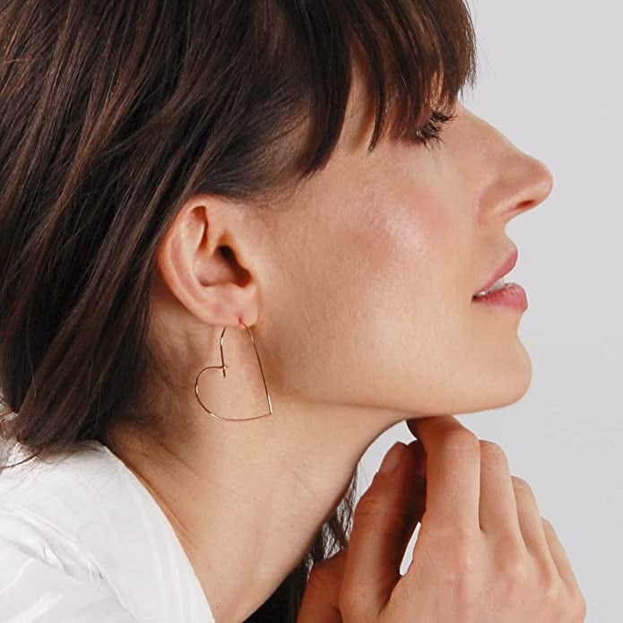 model wearing hoop earrings shaped like hearts