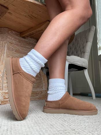 reviewer wearing the white slouch socks with brown Ugg booties