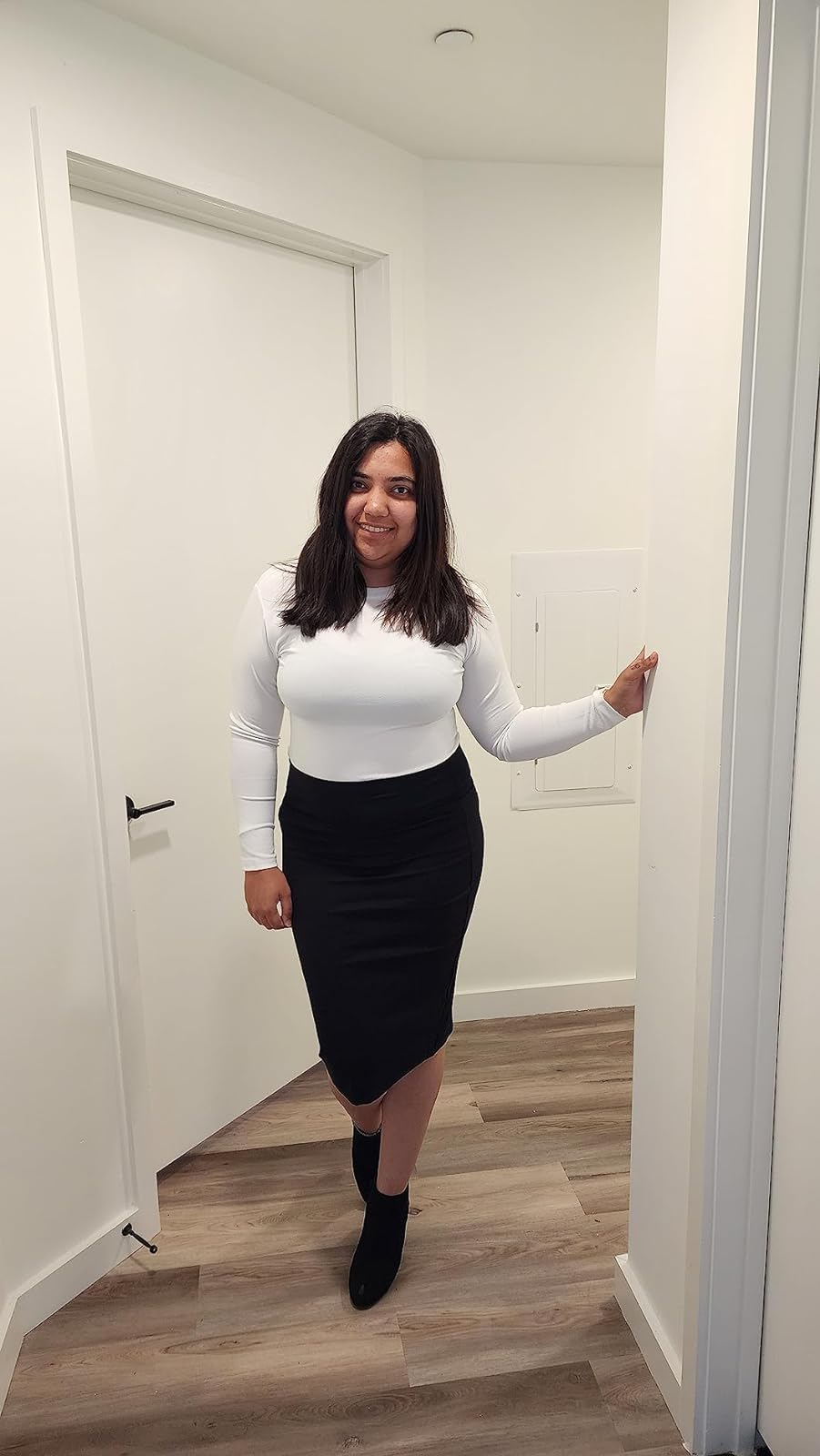 Reviewer in a white top, black skirt, and ankle boots