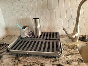 reviewer photo of dish rack folded flat next to sink