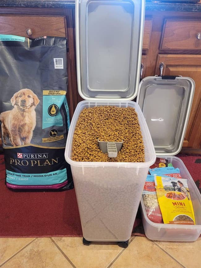 The the storage container next to a 34 pound bag of dog food