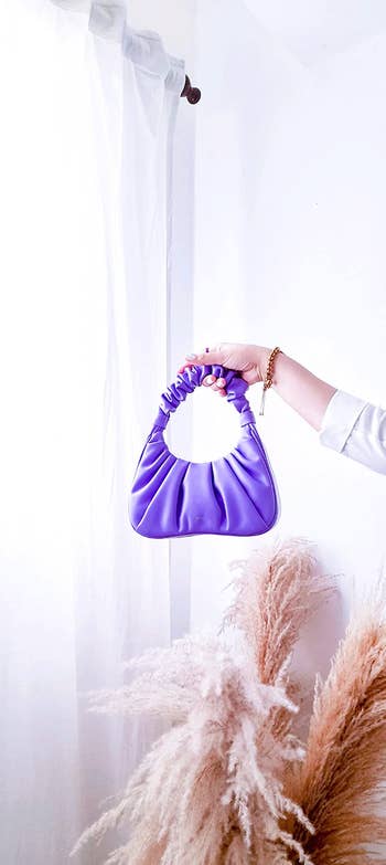a reviewer holding up the bag in light purple