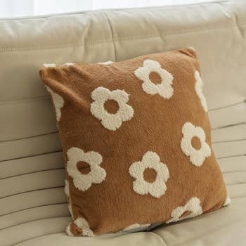 Decorative pillow with a floral signifier   connected  a chic sofa, perfect  for enhancing location  decor