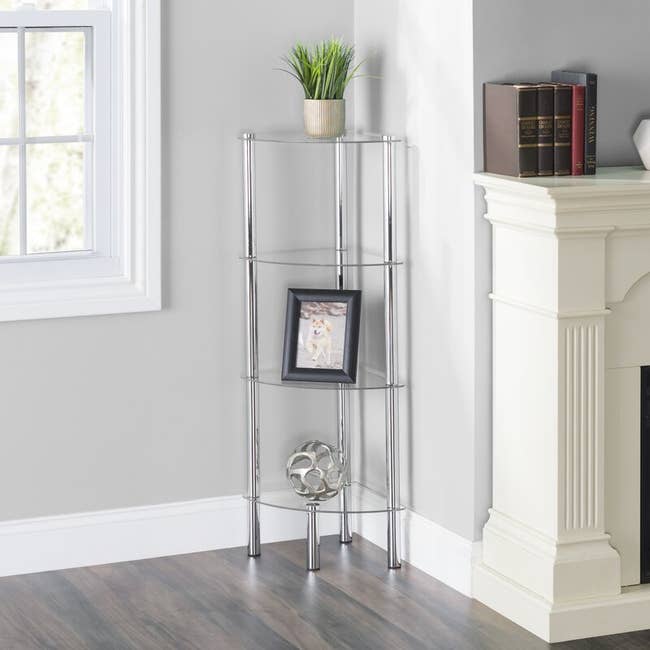 Silver metal and clear four-tier shelf with decor on display