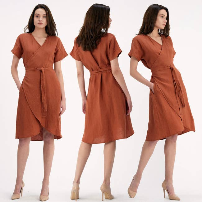 Model is wearing the short linen wrap dress in a burnt orange color with nude heels