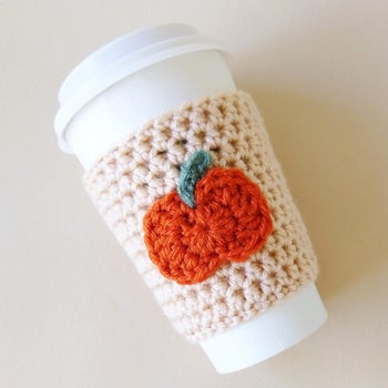 a knit coozy with a pumpkin in the middle