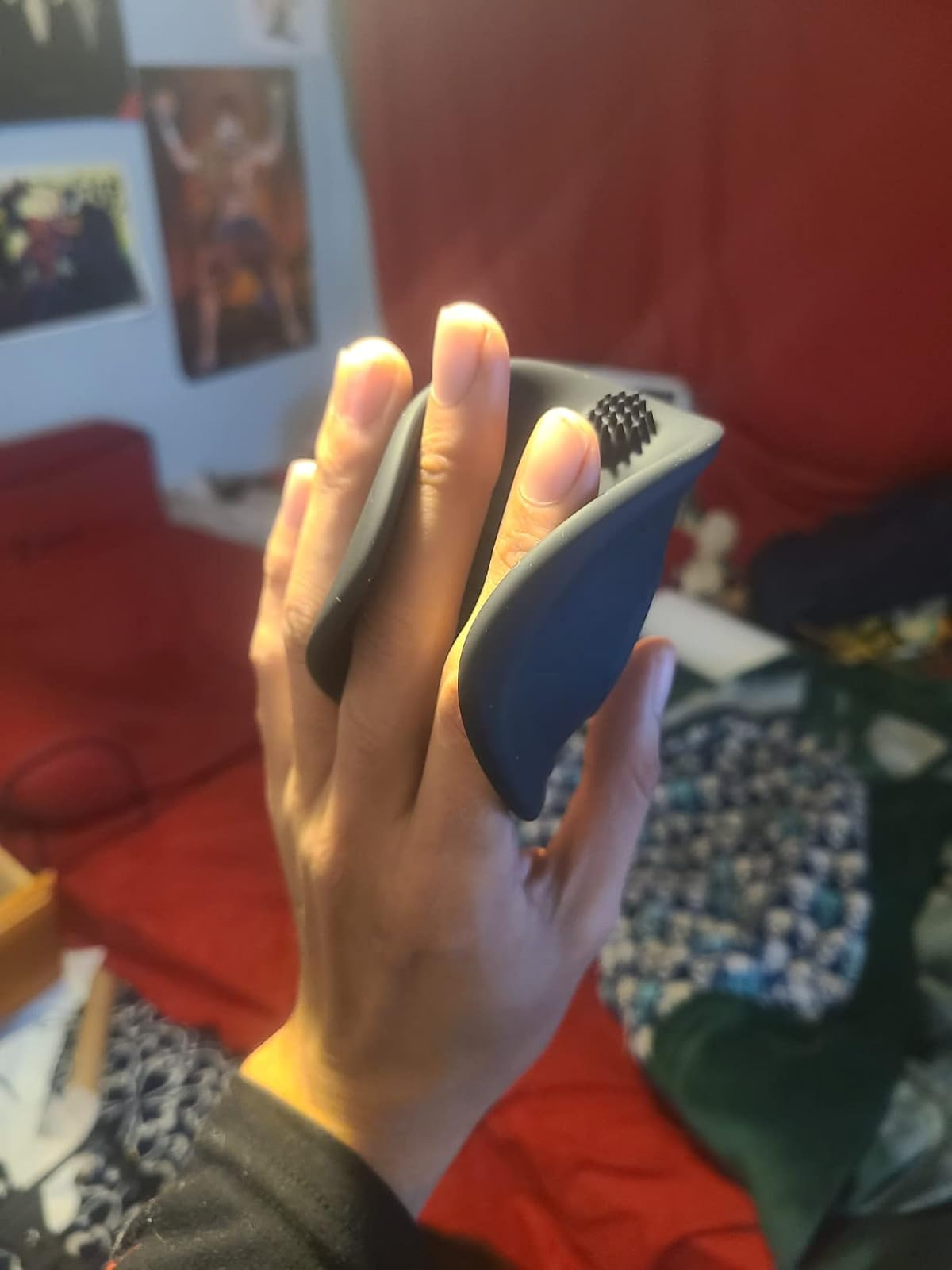 Hand holding a achromatic  silicone vibrating stroker with a textured nub connected  the wrong  of the sleeve