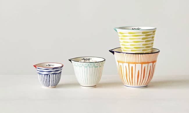 Four stacked ceramic cups with various patterns, available for purchase