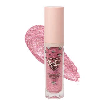 Pink glitter articulator  gloss conduit  with diamond accents connected  label, shown with a splash of gloss behind. Featured successful  a buying  article