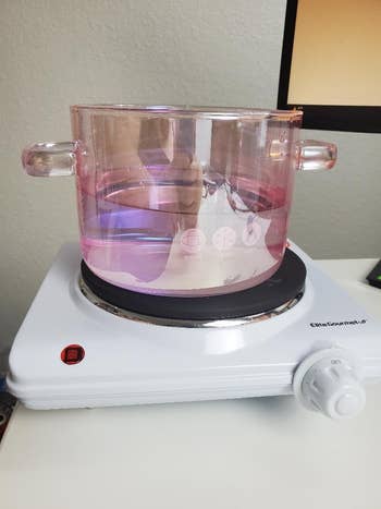 a reviewer's burner with a purple pot on top