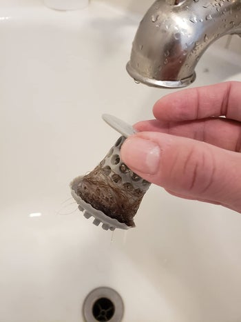 same reviewer pulling the gray tubshroom filled with hair out of the drain