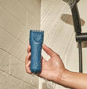 Model holding blue razor in the shower 