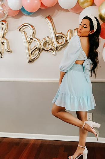 Reviewer wearing blue mini dress