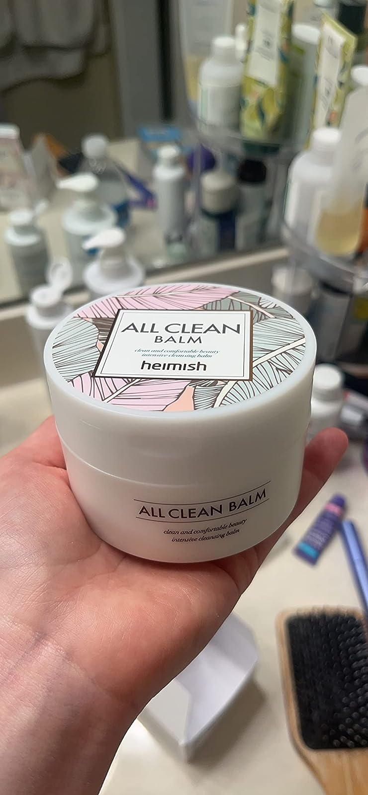 Reviewer holding the jar of balm