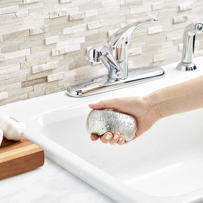 model holding the soap bar-shaped stainless steel, with the text 