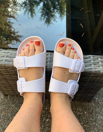 reviewer wearing the white double buckle slides