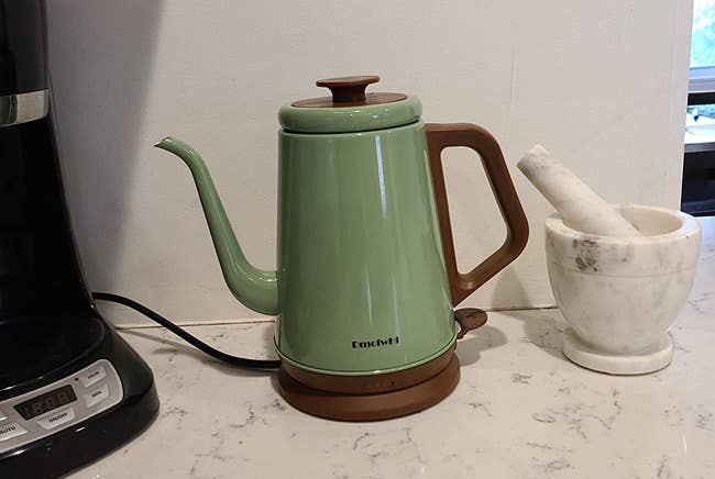 Reviewer's pale seafoam green kettle with brown accents on their counter