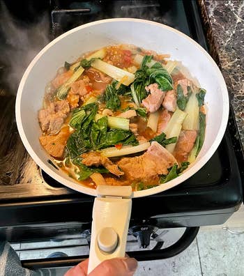 Reviewer cooking stir fry in a cream white colored pan 