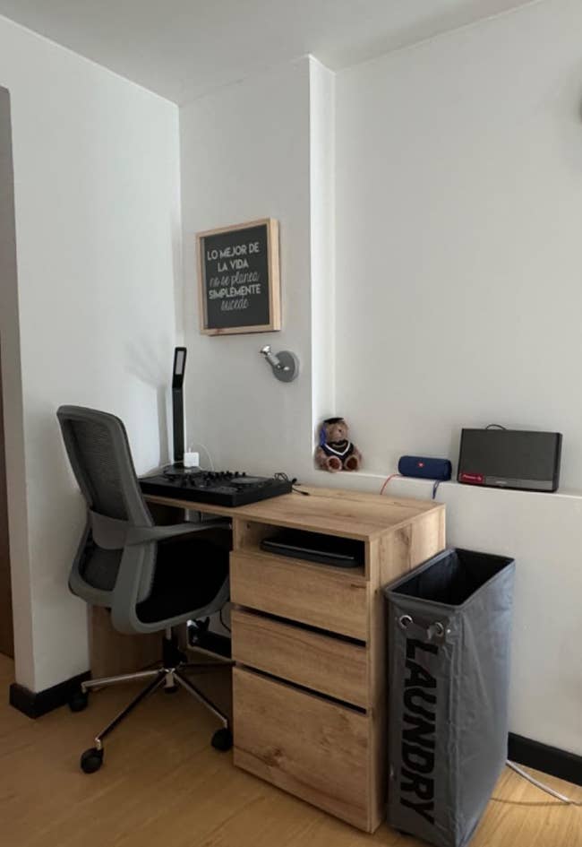 The laundry hamper sitting adjacent to a desk
