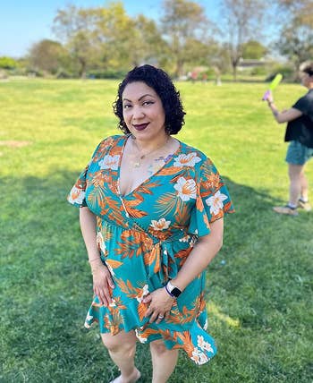 reviewer in the green floral V-neck wrap dress