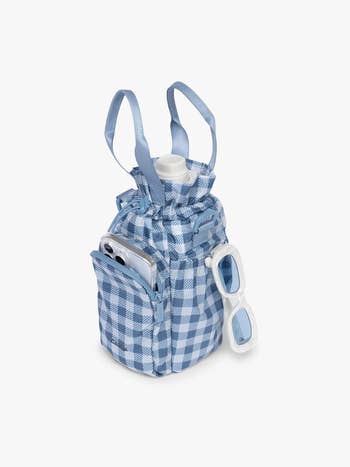Plaid mini container  styled arsenic  a picnic basket, with a telephone  and sunglasses tucked successful  pockets