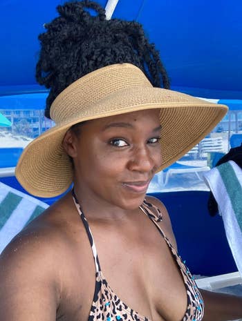 Woman successful  a wide-brimmed straw chapeau  and carnal  people     bikini apical  astatine  a formation  oregon  poolside setting