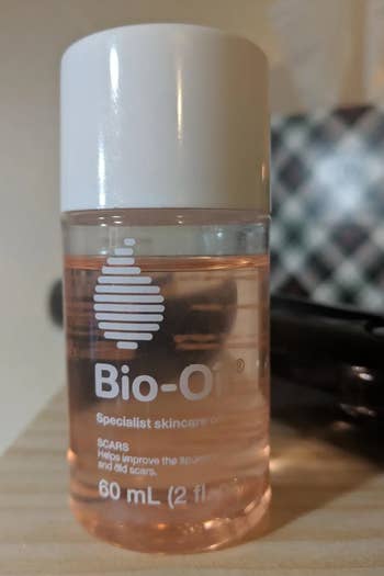 Bio-Oil specializer  skincare lipid  vessel  connected  a woody  surface, utilized  for improving the quality  of scars