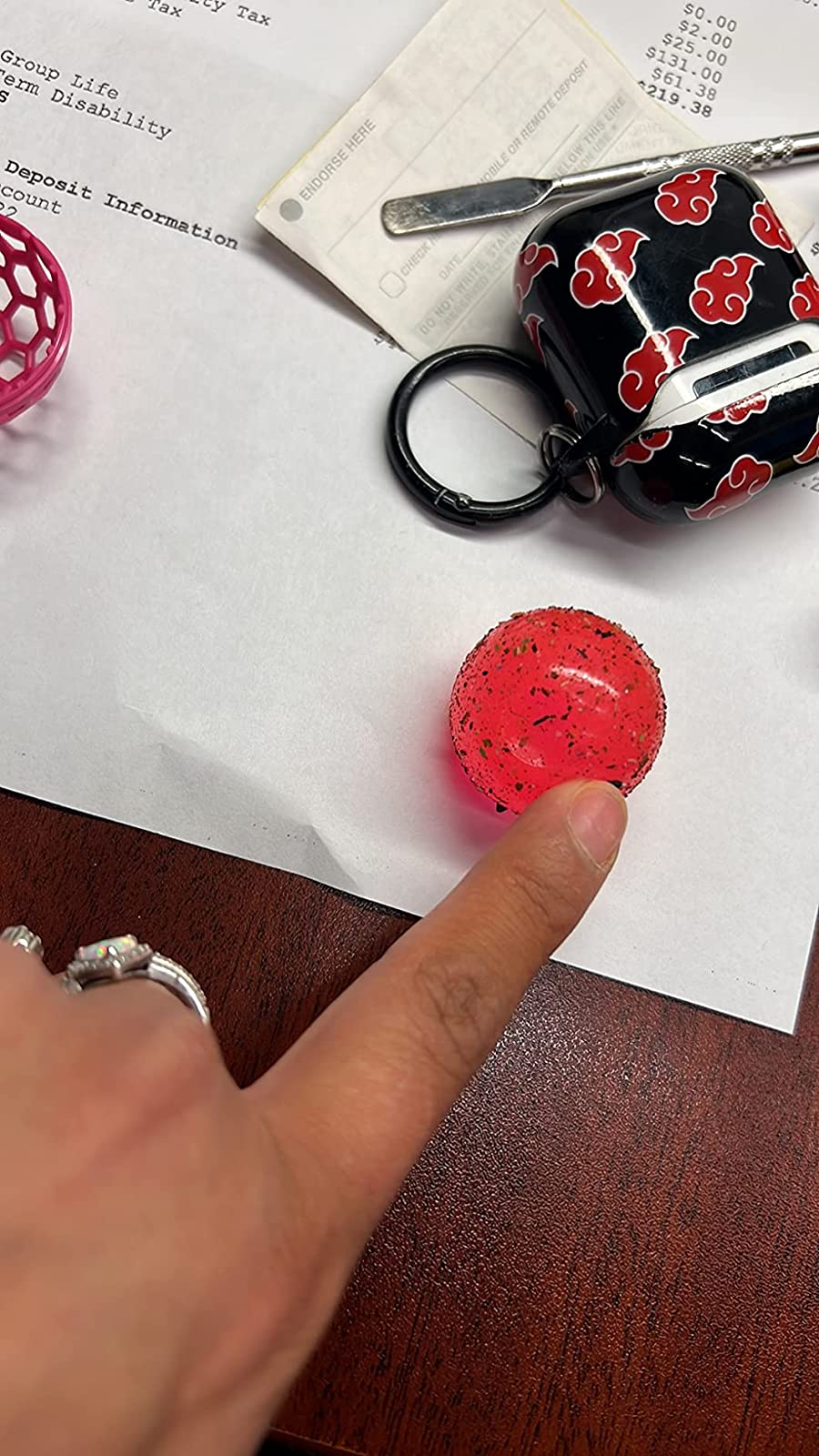 reviewer's finger on the pink ball, which is covered in dust and crumbs 