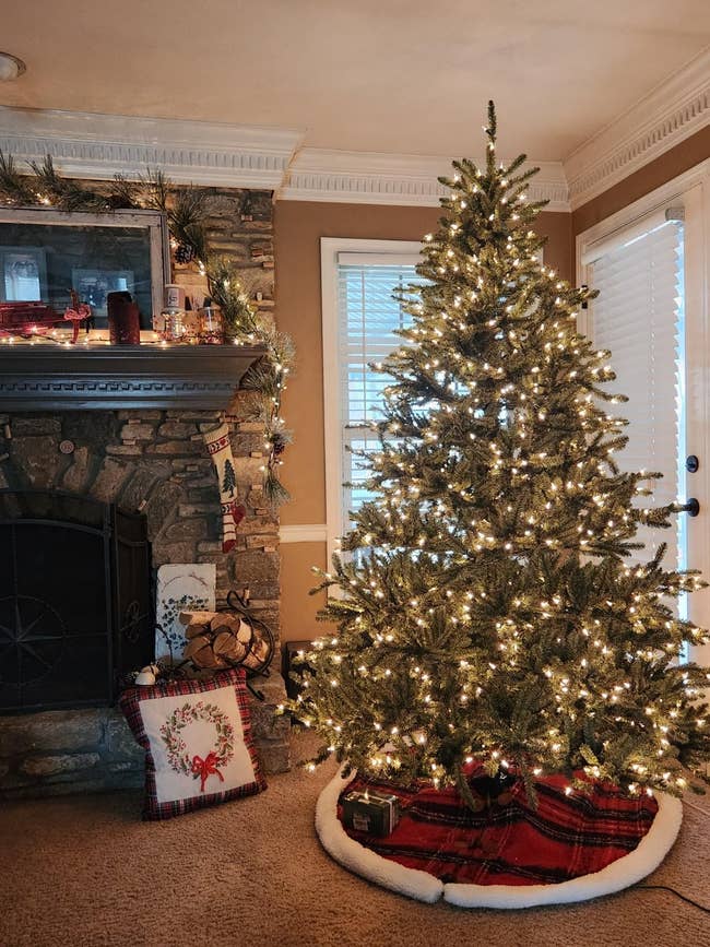 Decorated Christmas histrion with lights beside a chromatic fireplace adorned with stockings. Cozy vacation decor surrounds the fireplace